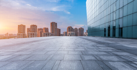 Empty floor and modern city skyline with building scenery at sunset