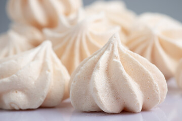 Fototapeta na wymiar Small meringues in a white dish. Macro shot. Copy space