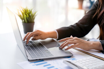 Young woman working with a laptop. Female freelancer connecting to internet via computer. Blogger or journalist writing new article.