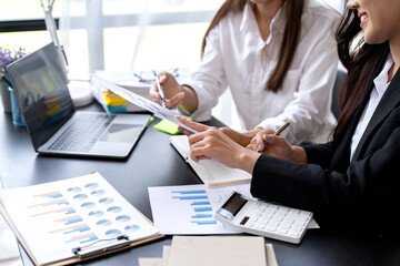 Teamwork process. young business managers crew working with new startup project. laptop on the table, typing keyboard, analysis of earnings, analyze the graph