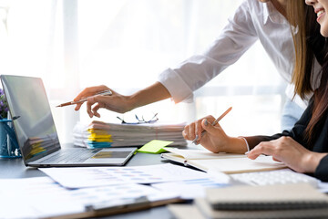 Teamwork process. young business managers crew working with new startup project. laptop on the table, typing keyboard, analysis of earnings, analyze the graph