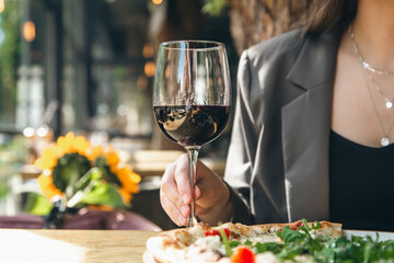 A glass of red wine in a restaurant on a table close-up.