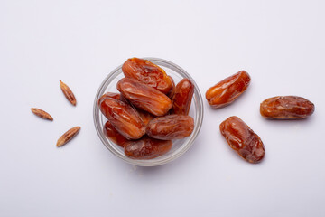Bowl of pitted dates isolated on white background, top view
