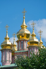 Fototapeta na wymiar a fragment of the exterior of an Orthodox church with stucco and gilded domes and crosses