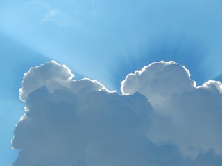 Beautiful sky background. Clouds in the blue sky illuminated by the sun. - 523578524