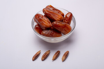 Bowl of pitted dates isolated on white background, top view
