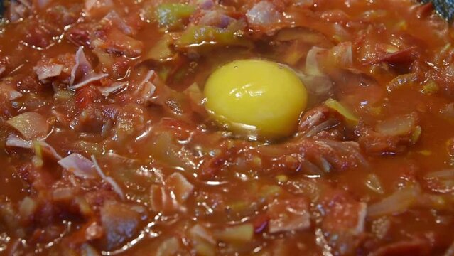 Drop the egg into the vegetable mixture. cooking lecho