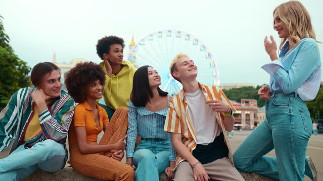 Multiethnic group of friends going out after school and having fun. Staying connected using technology and showing funny stuff online