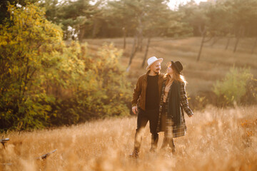 Lovely hipster couple resting in nature. People, lifestyle, relaxation and vacations concept. Autumn Fashion, style concept.