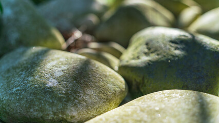 Smooth large stones in backlit sunlight, natural background image, natural stones, selective focus