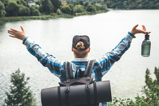 Male traveler with backpack and karimat in nature, back view.