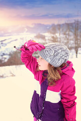 Fototapeta na wymiar young girl in a winter day in the mountains looks into the distance