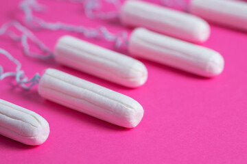 Medical female tampon close up on a pink background. Hygienic white tampon for women. Cotton swab.