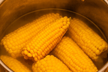 Hot corn in a metal pan, vegetarian food, boiled yellow mature corn, healthy organic food