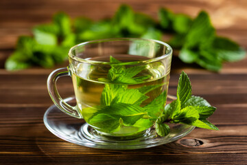 Cup of mint tea and a bunch of mint on the table