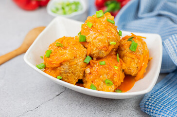 meatballs in a plate with onions and gravy