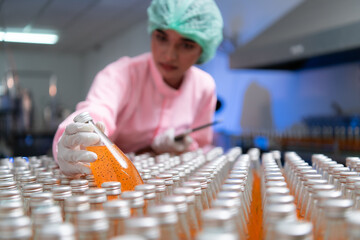 Product quality control staff at the fruit juice production line Perform product quality checks To...