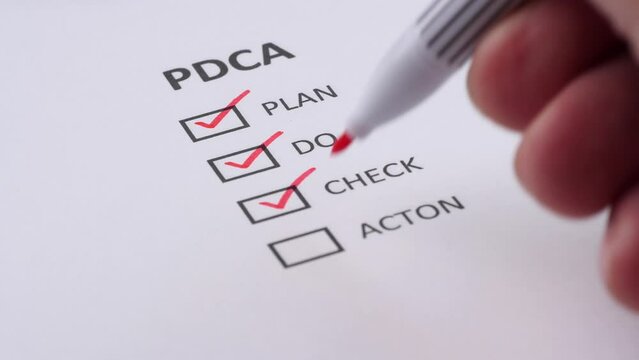 PDCA or PLAN, DO, CHECK, ACTION Business Management Concept. Businessman tick off or marking with red pen on the checklist, checkbox after completing task on white paper. Selective focus 4K resolution