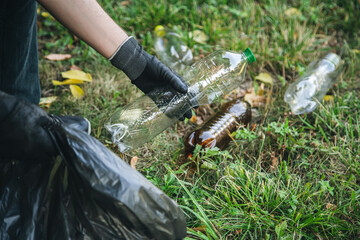 Close-up, a plastic bottle in a male hand, cleaning up nature.