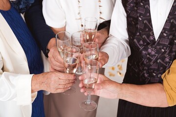 Group of older happy friends toasting with champagne during New Year's Eve