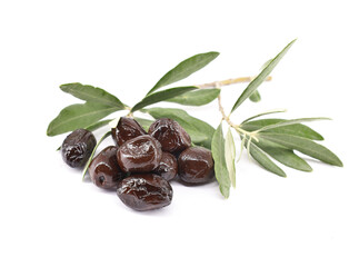 Dry salt cured black olives with leaves on white background.