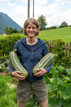 farmer woman with two big zucchinis from her plantation