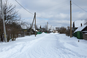 Empty snow covered road in winter landscape