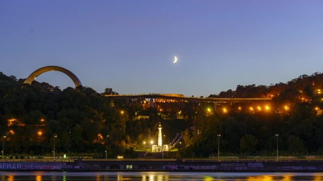 4K Timelapse of beautiful moonset above the pedestrian bridge near Arch of Friendship and park Volodumurska girka in Kyiv, Ukraine