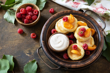 Healthy and delicious morning breakfast. Homemade cottage cheese pancakes gluten free (syrniki, curd fritters) with berries on wooden rustic background. Copy space.