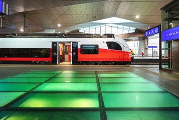 High speed train inside beautiful train station in Vienna, Austria. Red modern intercity passenger...