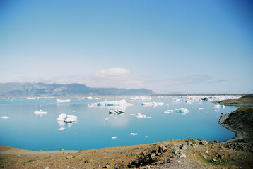 Icebergs in a blue glacial lake in Iceland. Grainy film in the style of old photos