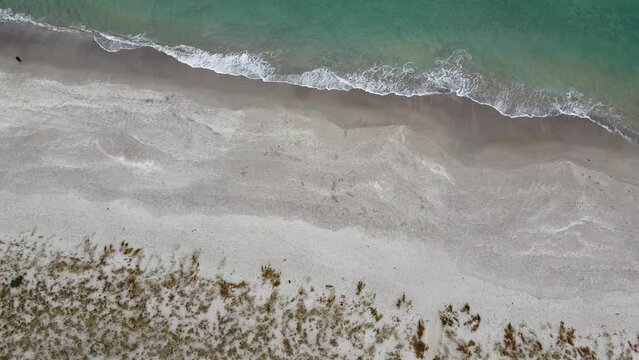 passeggiata solitaria in spiaggia vista dall'alto con drone