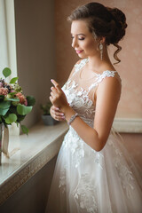 Bride puts on jewelry before the ceremony
