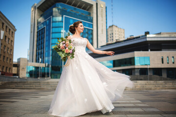 Happy bride standing at background of the city architecture