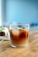 A glass of fresh iced coffee in a glass on a wooden table.