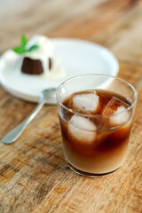 Overhead view of iced coffee in a glass on a wooden table.