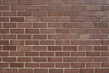 Naklejka premium The texture of a neat brown stone. Smooth brickwork with brown smooth stone. The texture of the wall of the English house.