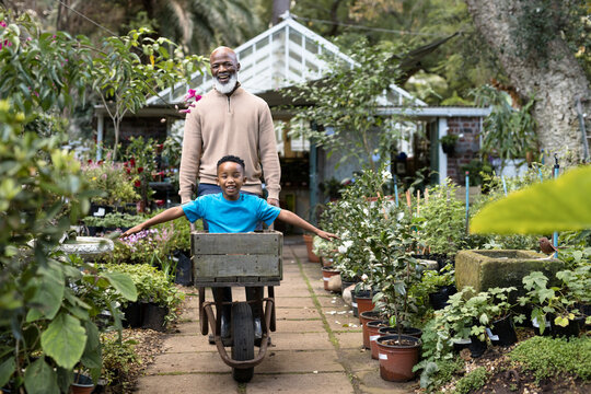 Portrait of happy senior african american man with his grandson in garden