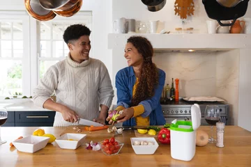Poster Image of happy diverse couple preparing meal in kitchen © wavebreak3