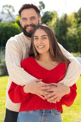 Obraz premium Portrait of happy caucasian couple standing in garden, smiling and embracing