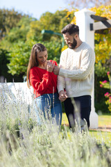 Happy caucasian couple having fun, laughing in sunny garden