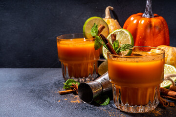 Spicy autumn pumpkin cocktail. Alcohol warming gin drink with pumpkin, lime, cinnamon, mint, autumn...