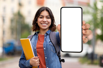 Arab Female Student Showing Blank Smartphone With White Screen While Standing Outdoors