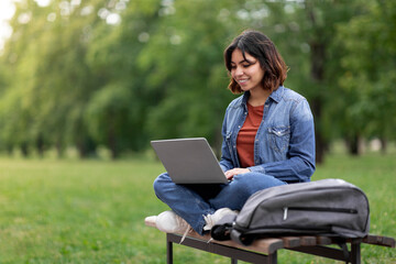 Distant Learning. Arab Female Student Using Laptop While Sitting On Bench Outdoors