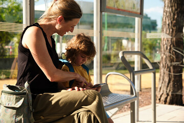 Mother and son waiting at the school bus stop