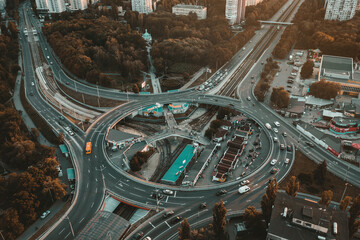 Fototapeta na wymiar Roundabout in the city - aerial drone shot. Ring road in a European city: car traffic on the road junction in the form of a ring. Aerial drone shot road ring.