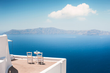 White architecture in Santorini island, Greece. Two chairs on the terrace with sea view.