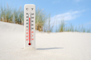 Hot summer day. Celsius and fahrenheit scale thermometer in the sand. Ambient temperature plus 40 degrees - obrazy, fototapety, plakaty