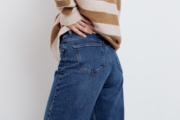 a close-up photo of stylish jeans from behind on a woman holding her hand near the pocket