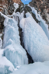 Fototapeta na wymiar Frozen waterfall in the mountains of the Zailiyskiy Alatau in Central Asia. Winter trip around the outskirts of Almaty.